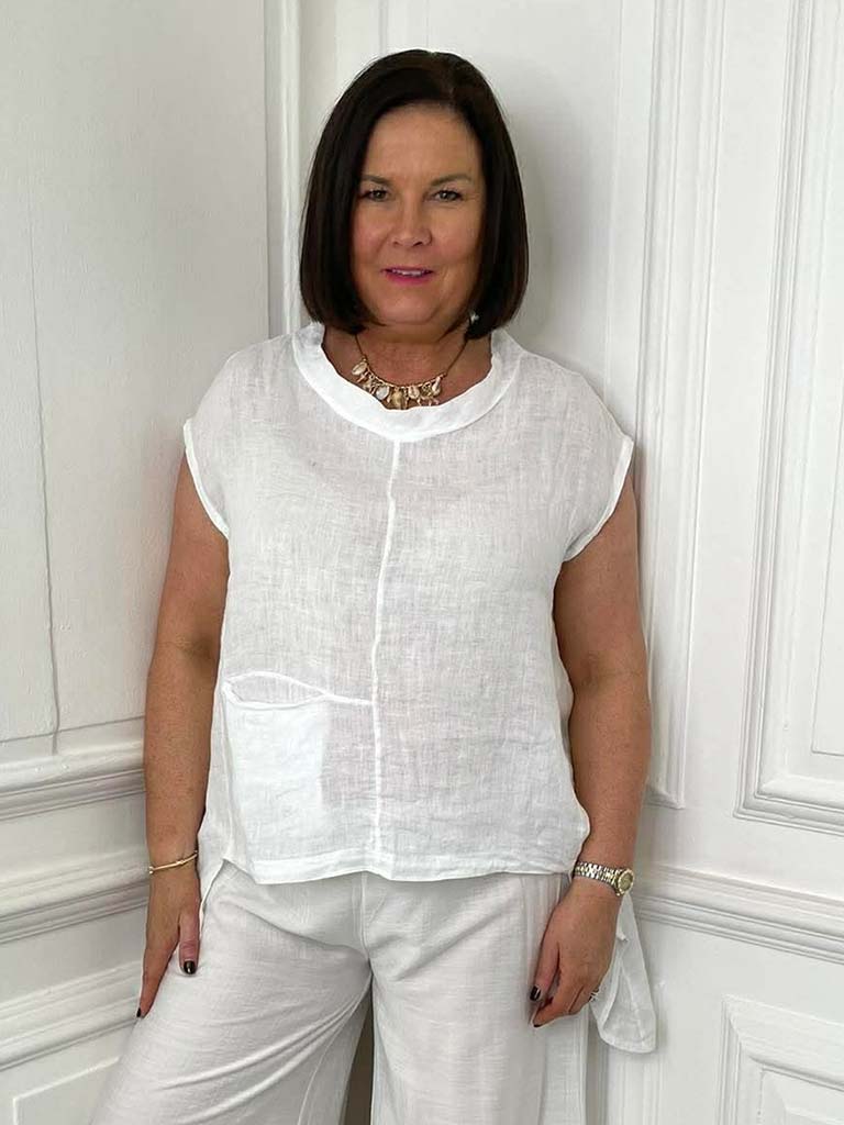 White linen dip-back top with short sleeves and front pocket, styled for relaxed womens fashion and everyday wear. - Linen Dip Back Top - White