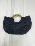 Black crochet handbag with circular wooden handles, featuring intricate textured pattern for relaxed styling and everyday. - Crochet Bag - Black