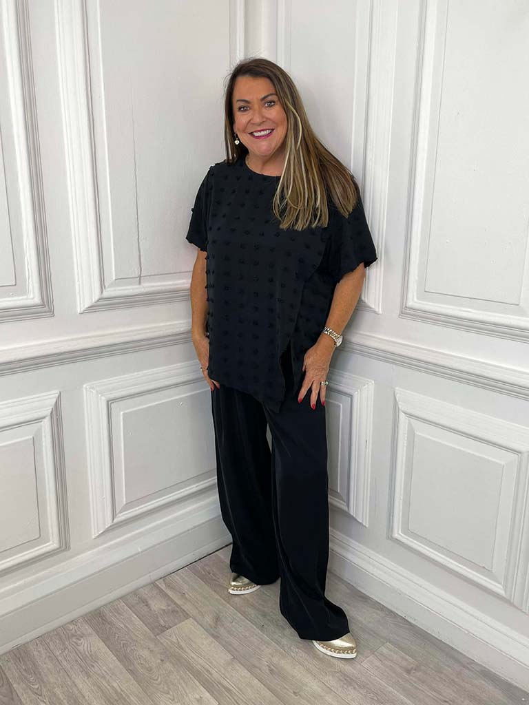 Black wide leg trousers paired with a relaxed short sleeve top, styled for everyday wear and modern womens fashion. - Malissa J Wide Leg Trousers - Black