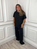 Black wide leg trousers paired with a relaxed short sleeve top, styled for everyday wear and modern womens fashion. - Malissa J Wide Leg Trousers - Black