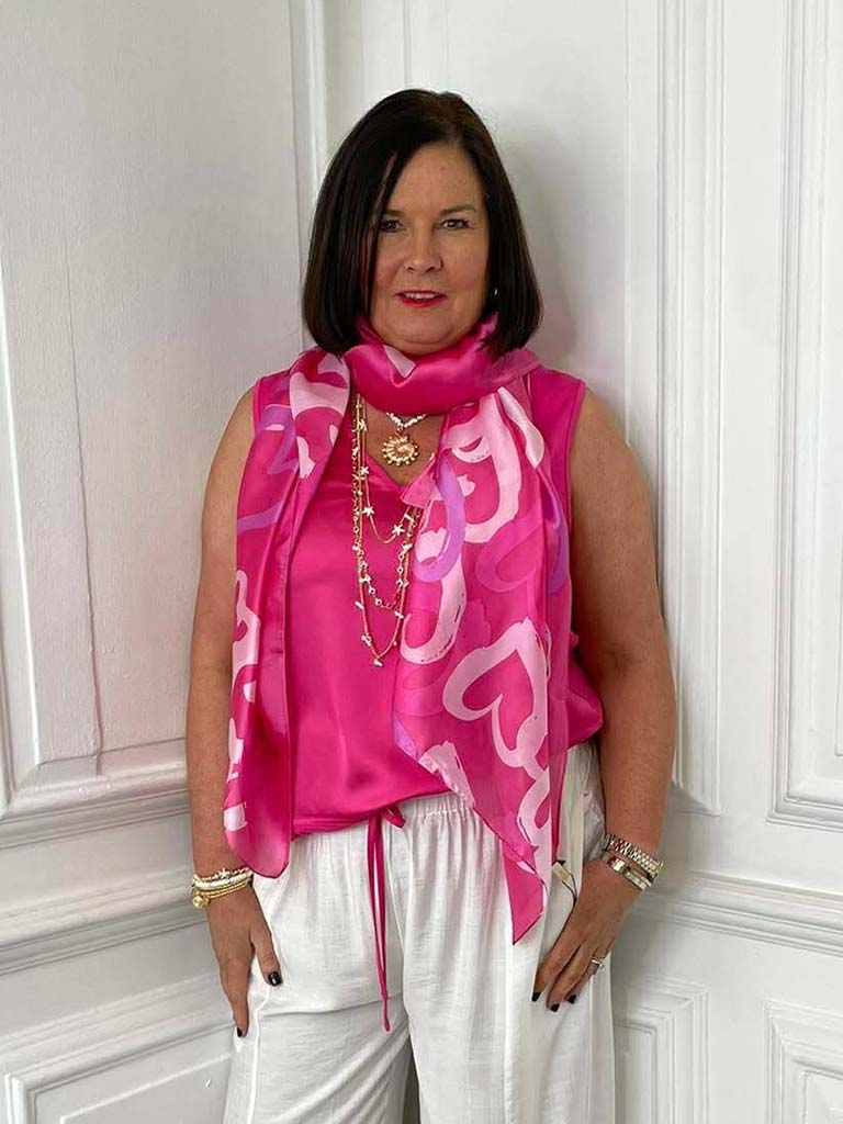 Pink heart-patterned scarf styled with sleeveless pink top and white pants for relaxed womens fashion and everyday wear. - Malissa J Heart Scarf - Pink
