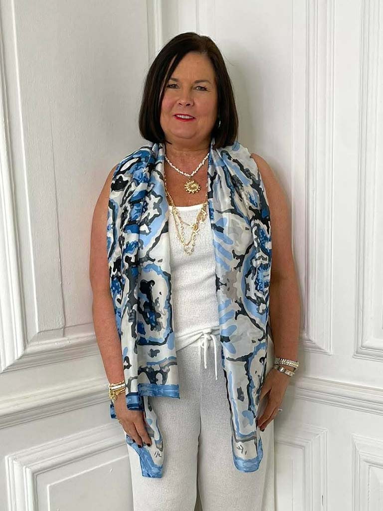 Blue kaleidoscope patterned scarf styled with white sleeveless top and light pants for modern women's fashion and relaxed. - Malissa J Kaleidoscope Scarf - Blue